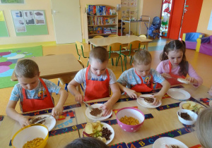 Dzieci smarują czekoladą wafle ryżowe.